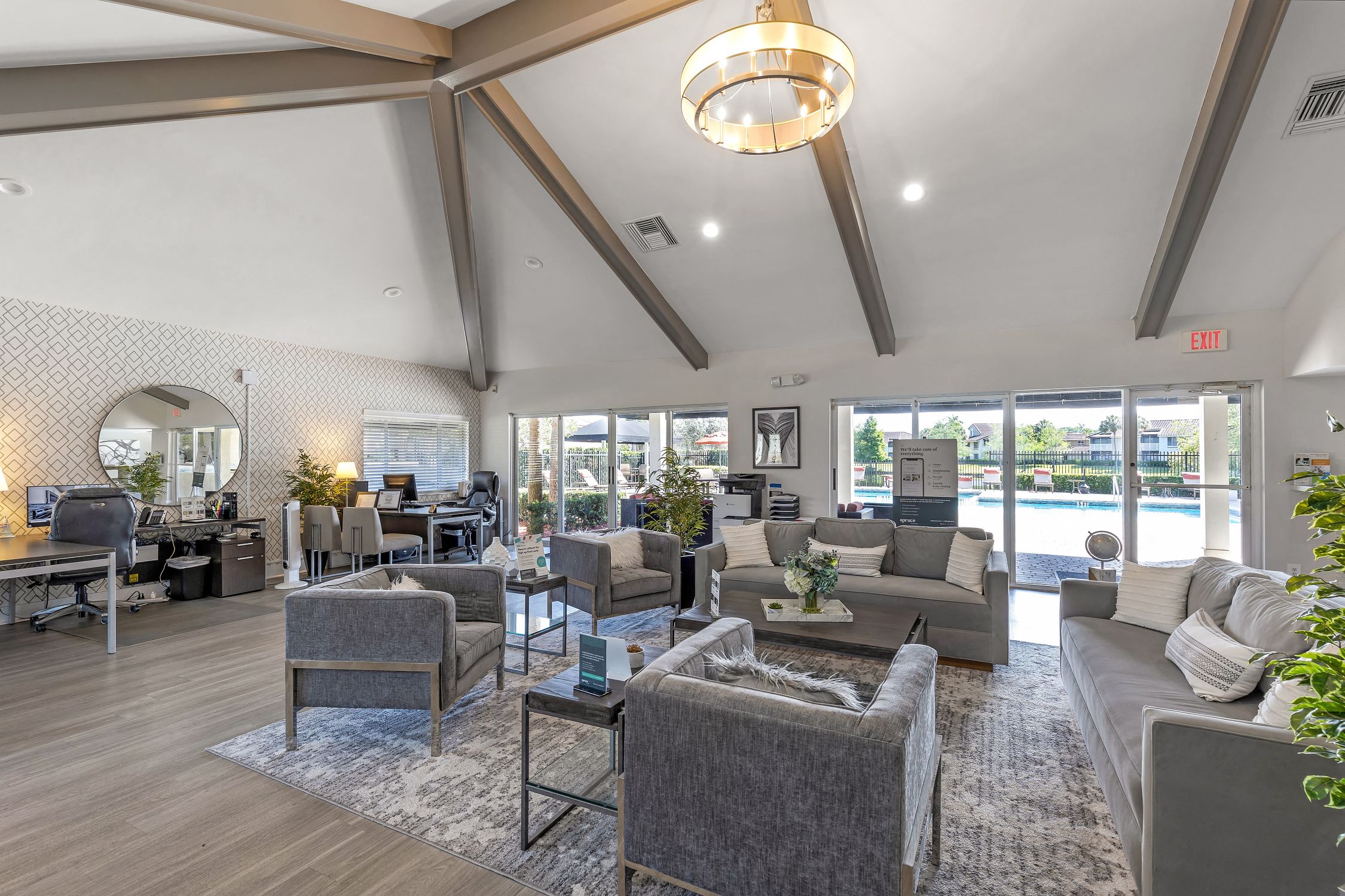 a living room with couches and chairs and a view of a pool